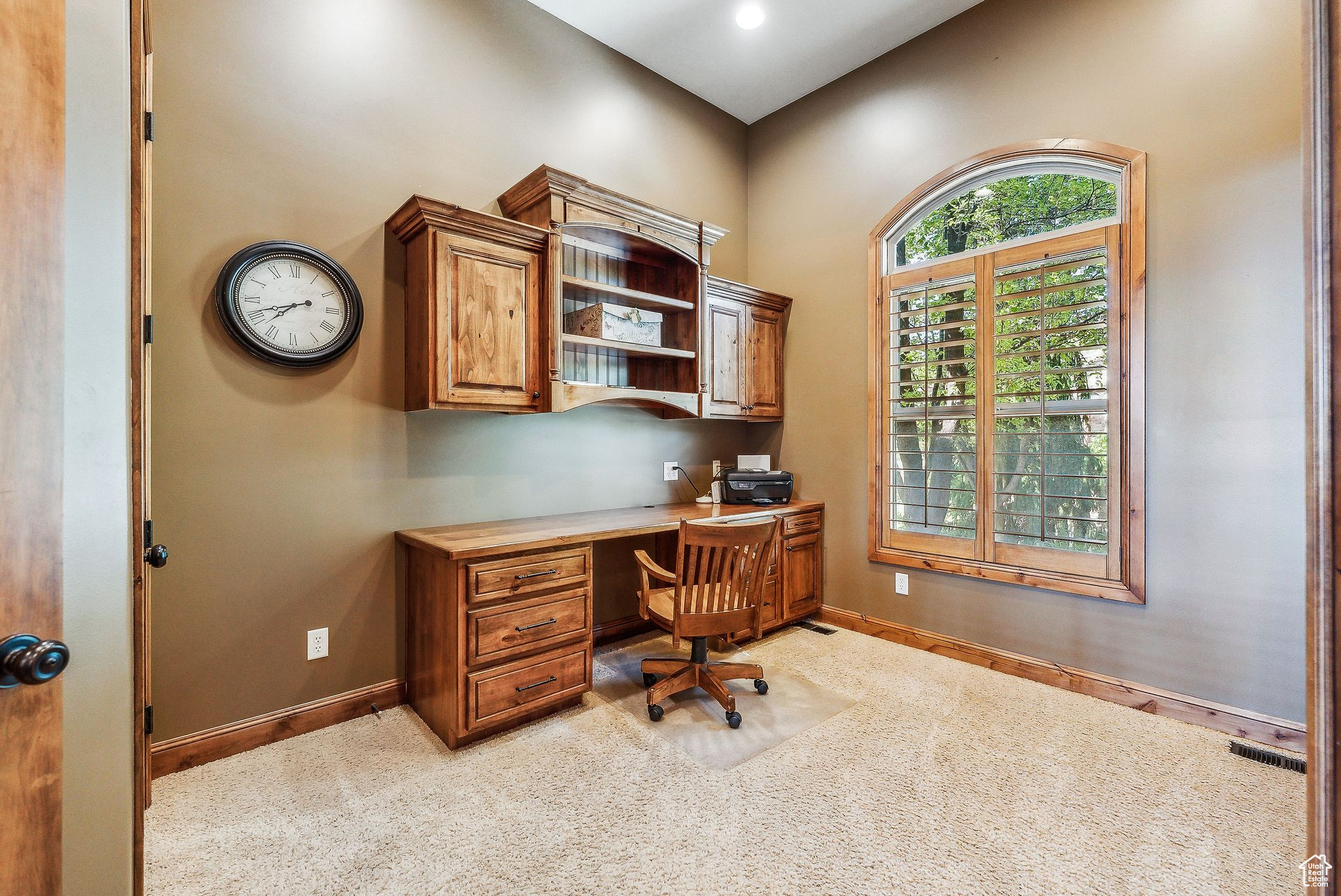 Office area with built in desk and carpet floors