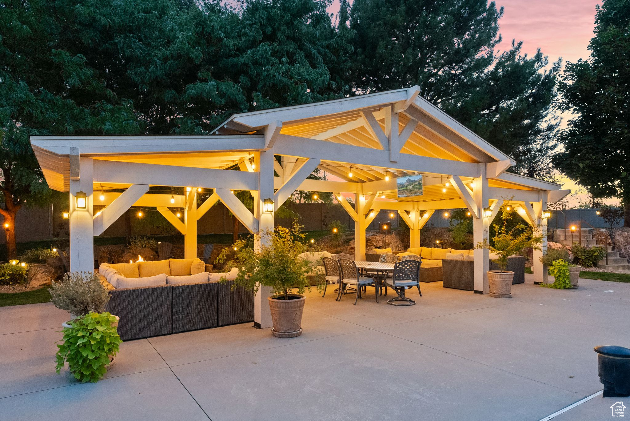 Patio terrace at dusk with an outdoor living space and a gazebo