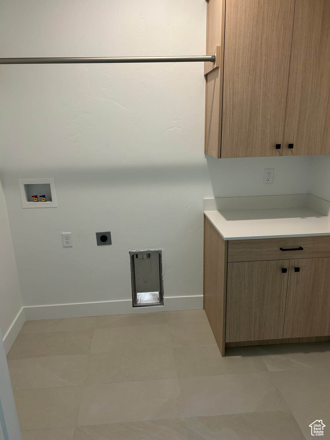 Laundry area featuring hookup for a washing machine, cabinets, electric dryer hookup, and light tile patterned flooring