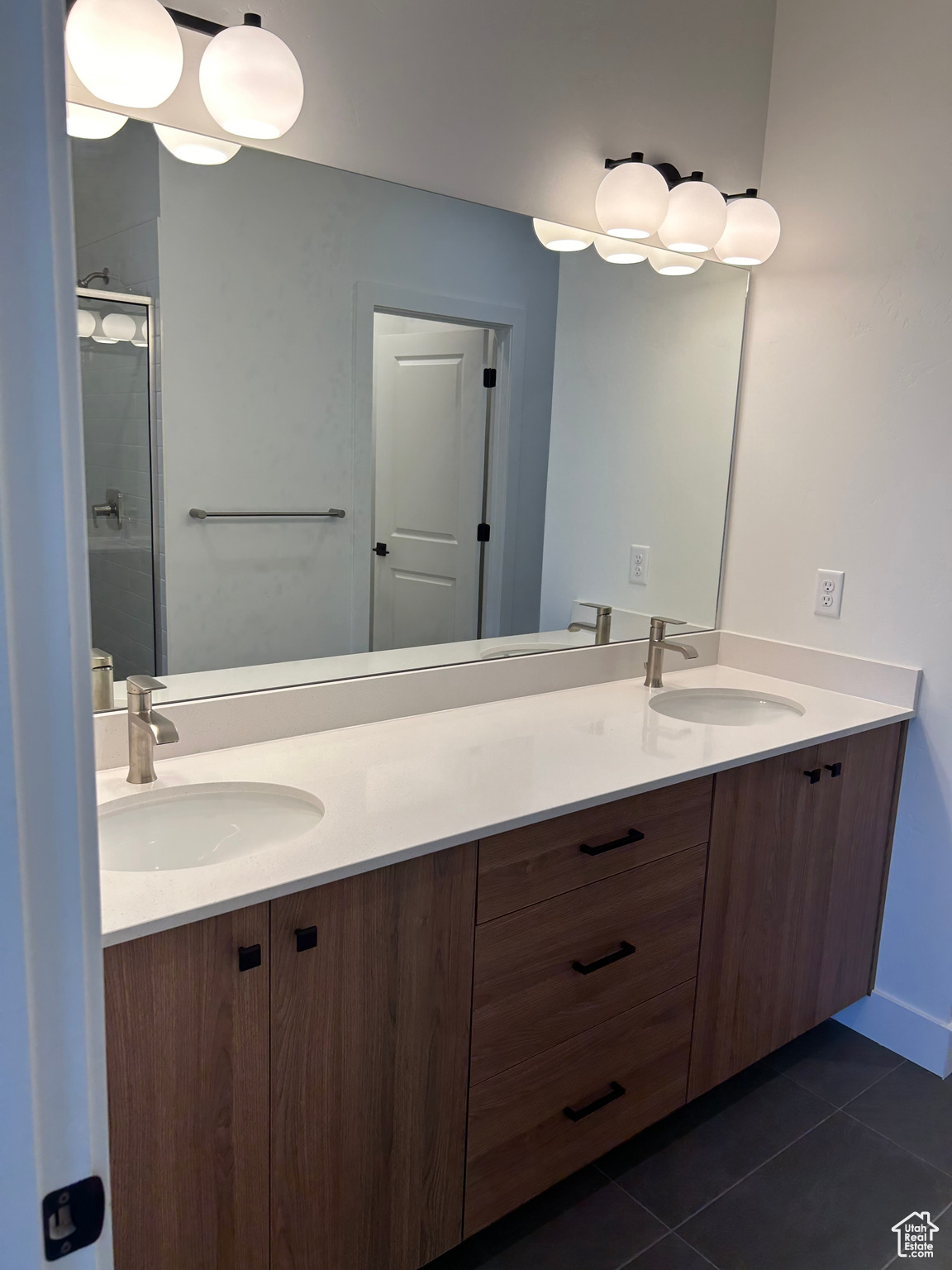 Master Bathroom featuring vanity, double sink, an enclosed shower, and tile patterned floors