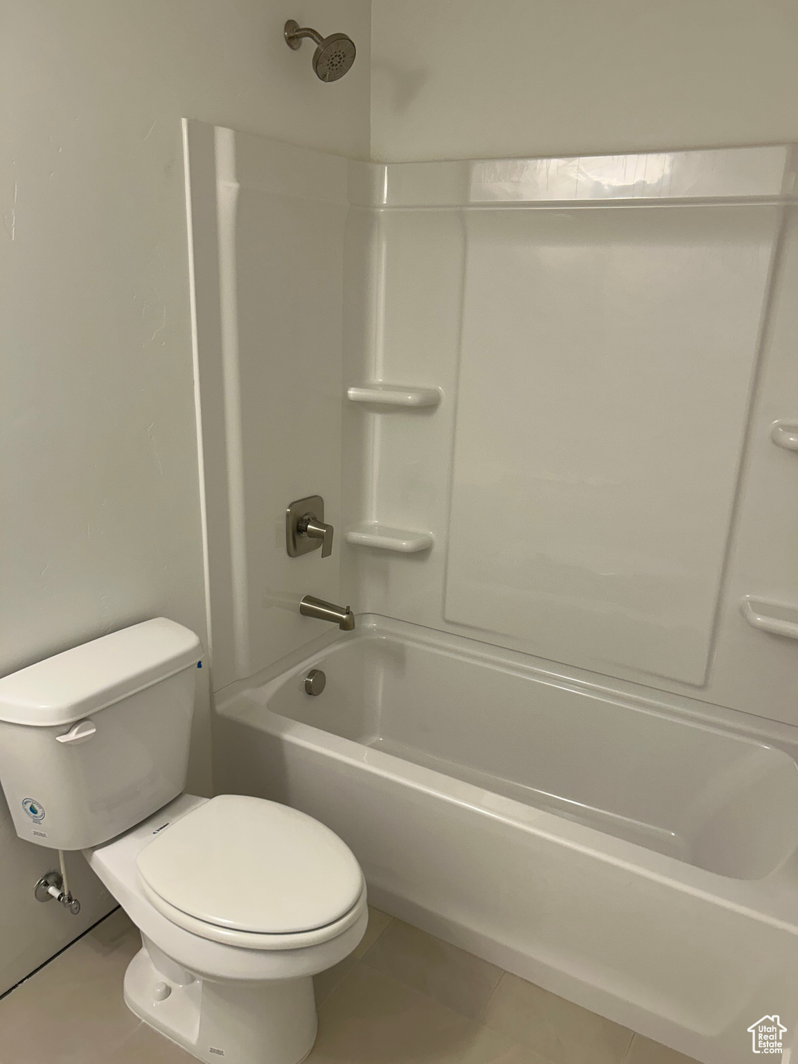 Downstairs Full Bathroom featuring bathtub / shower combination, toilet, and tile patterned floors