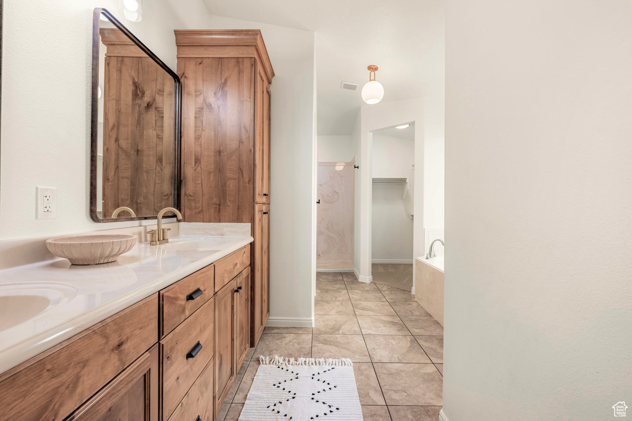 Bathroom with vanity, a bathing tub, and tile patterned floors