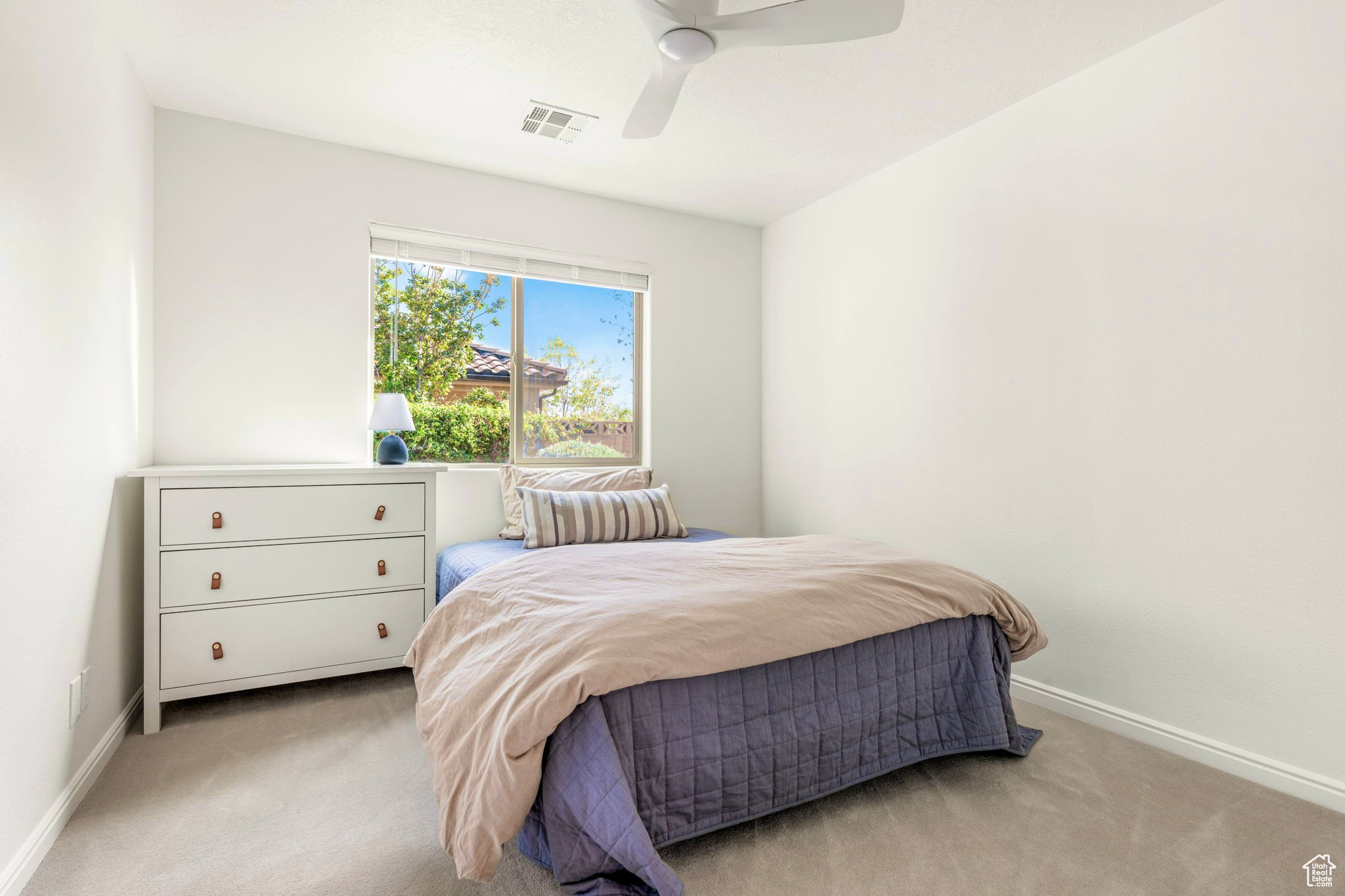 Bedroom with ceiling fan and light carpet