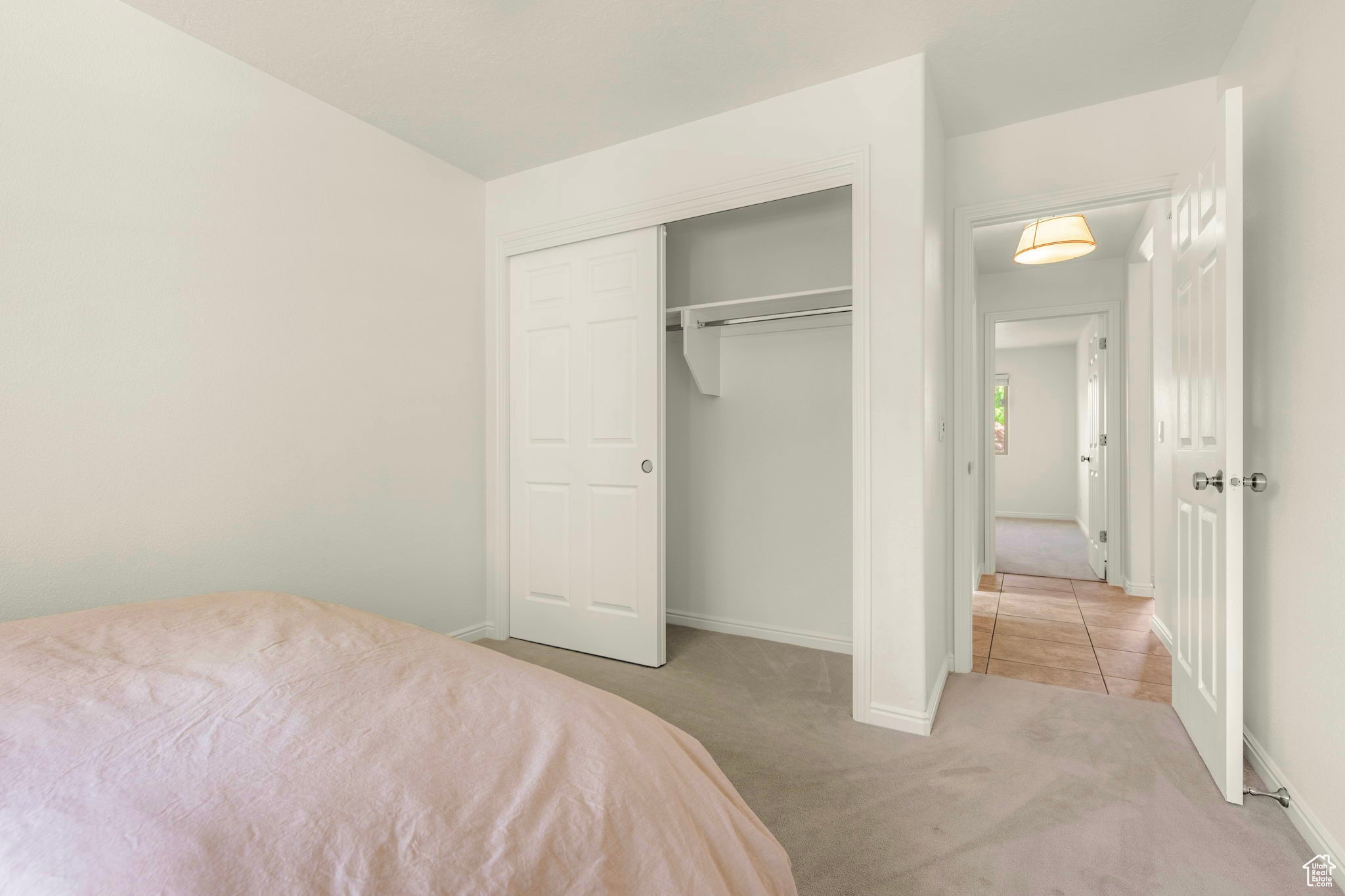 Unfurnished bedroom featuring a closet and light carpet