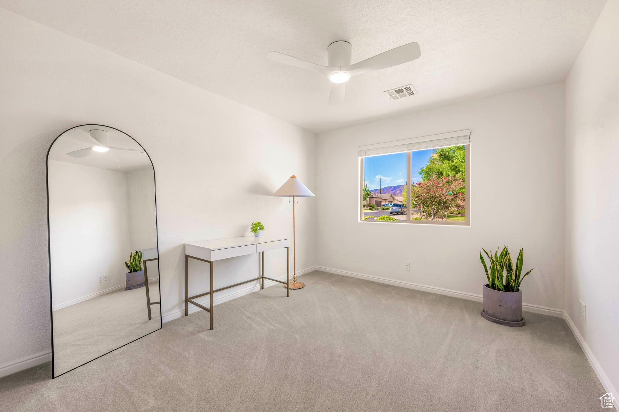 Interior space with light carpet and ceiling fan