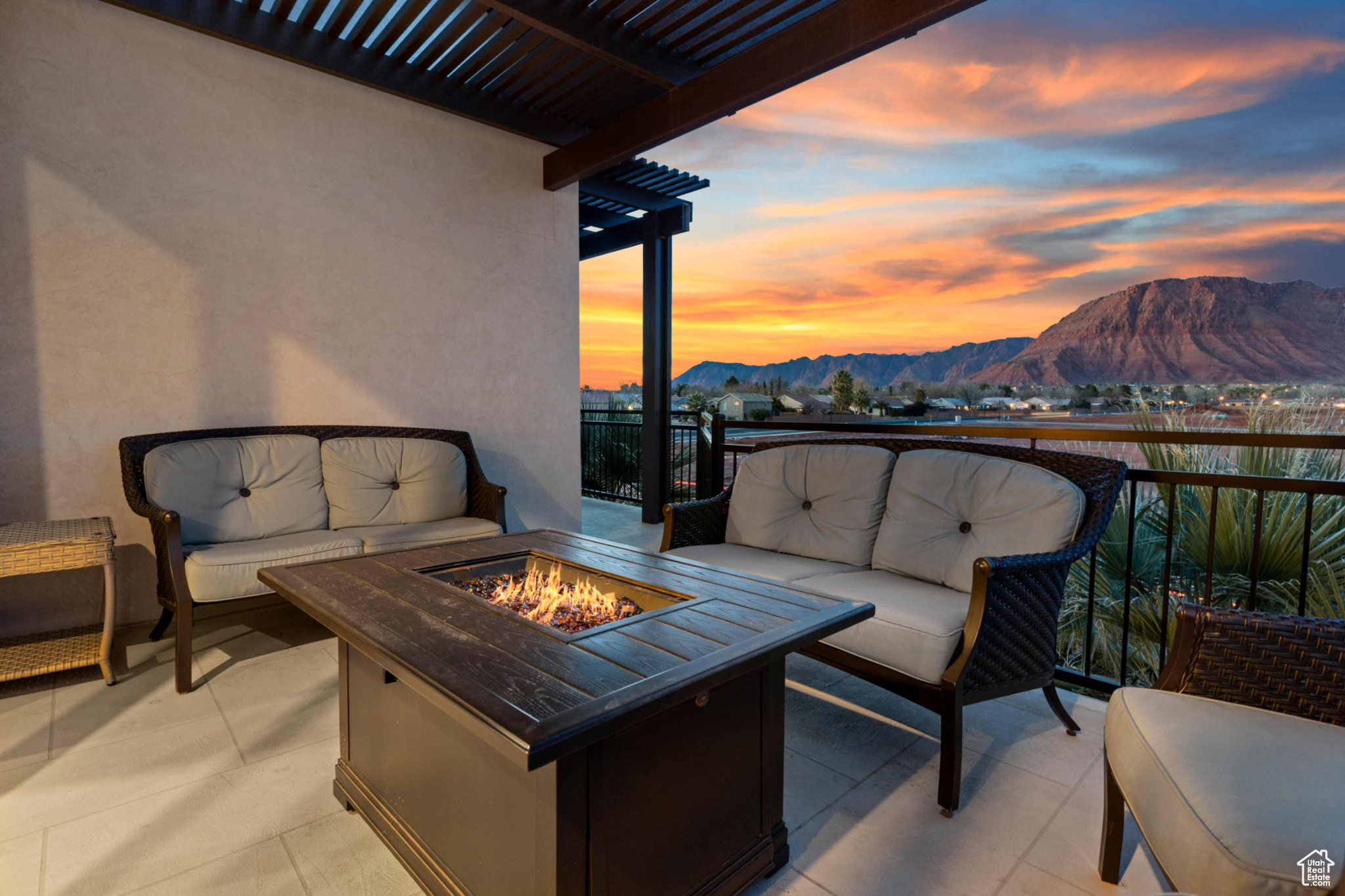 Balcony at dusk with an outdoor living space with a fire pit, a mountain view, and a pergola