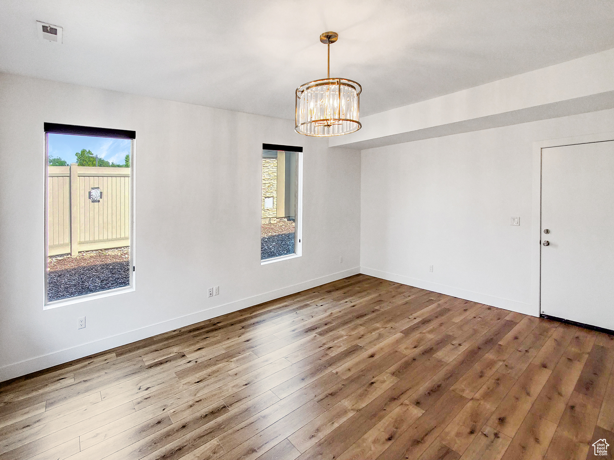 Spare room featuring hardwood / wood-style flooring and a healthy amount of sunlight