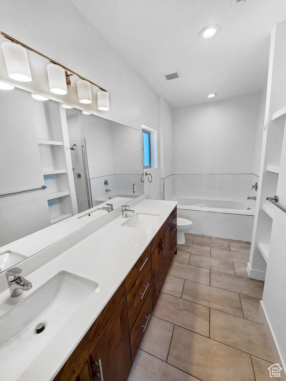 Full bathroom featuring vanity, toilet, plus walk in shower, and tile patterned floors