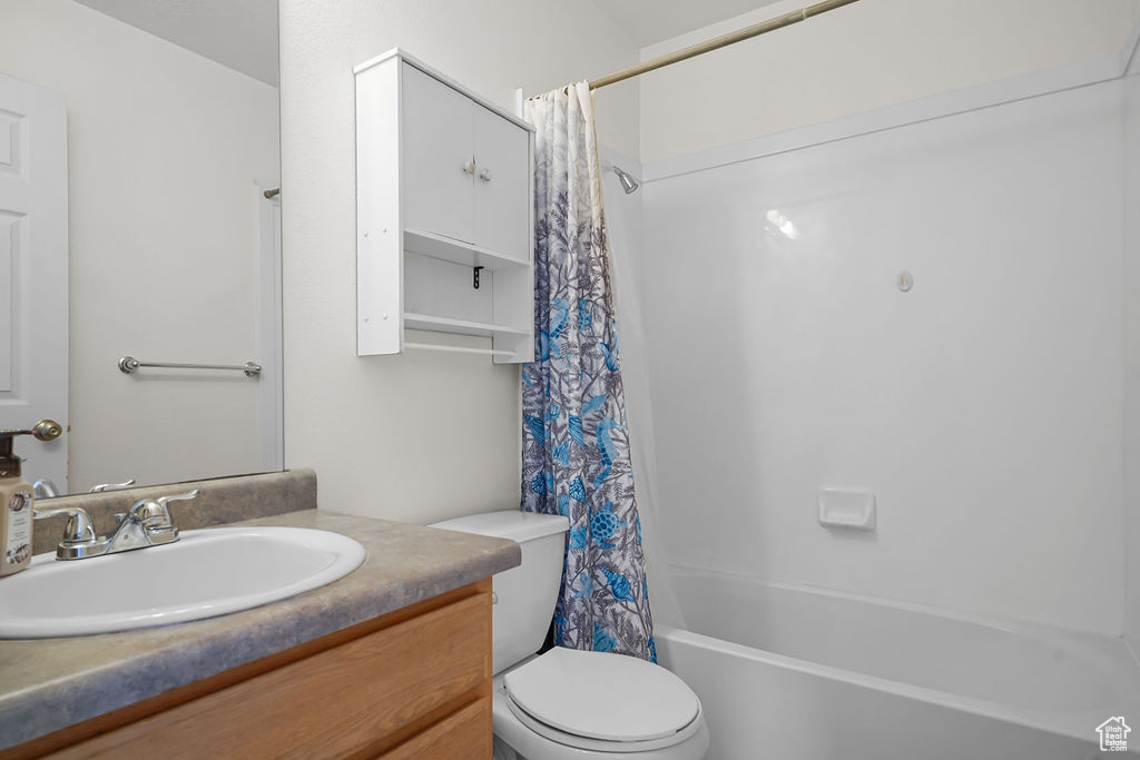 Full bathroom with vanity, toilet, and shower / bath combination with curtain