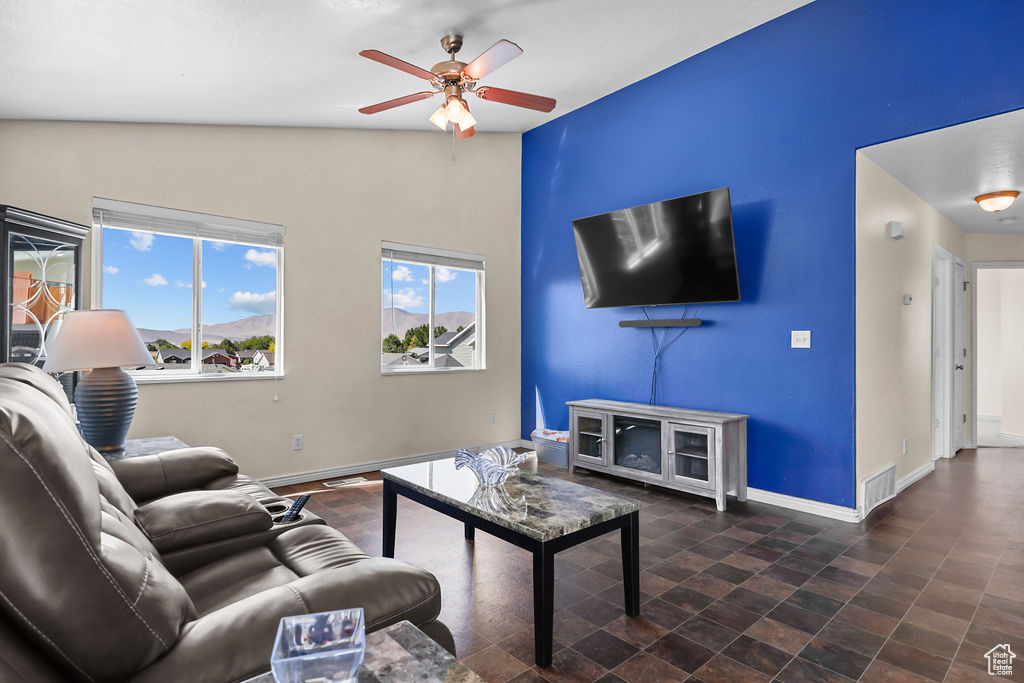 Living room featuring ceiling fan and vaulted ceiling