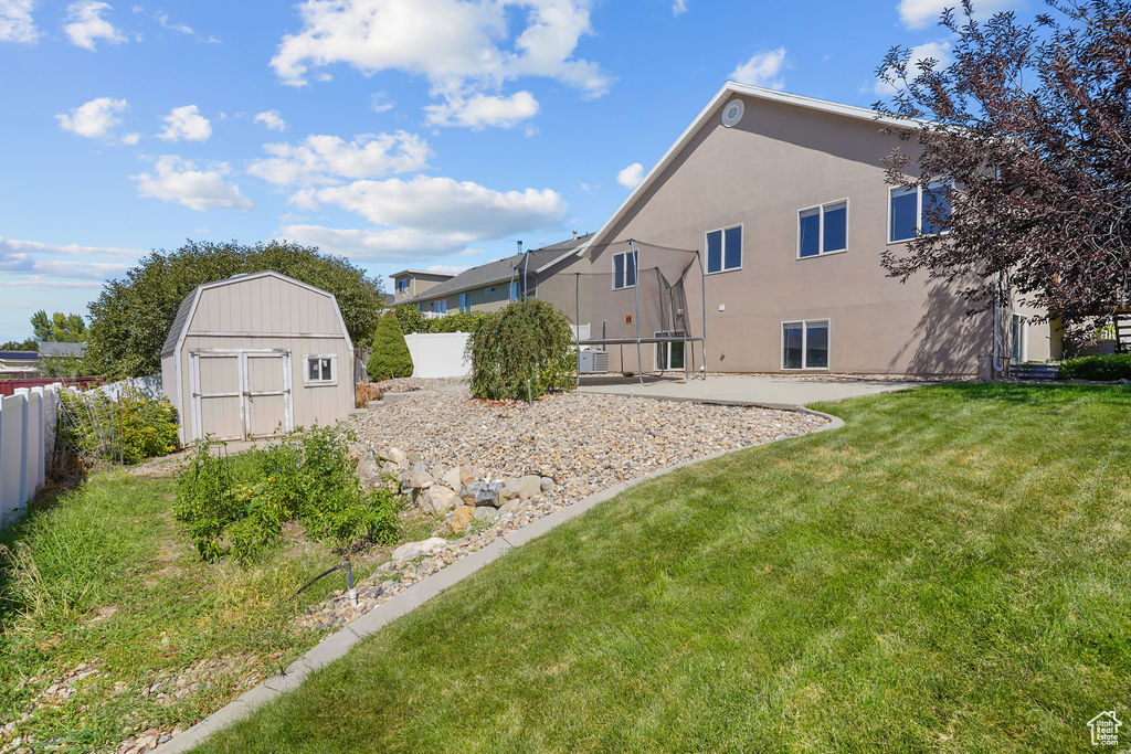 Exterior space featuring a storage shed, a yard, and a patio area