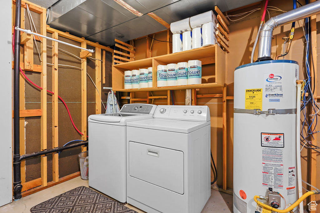 Clothes washing area featuring gas water heater and independent washer and dryer