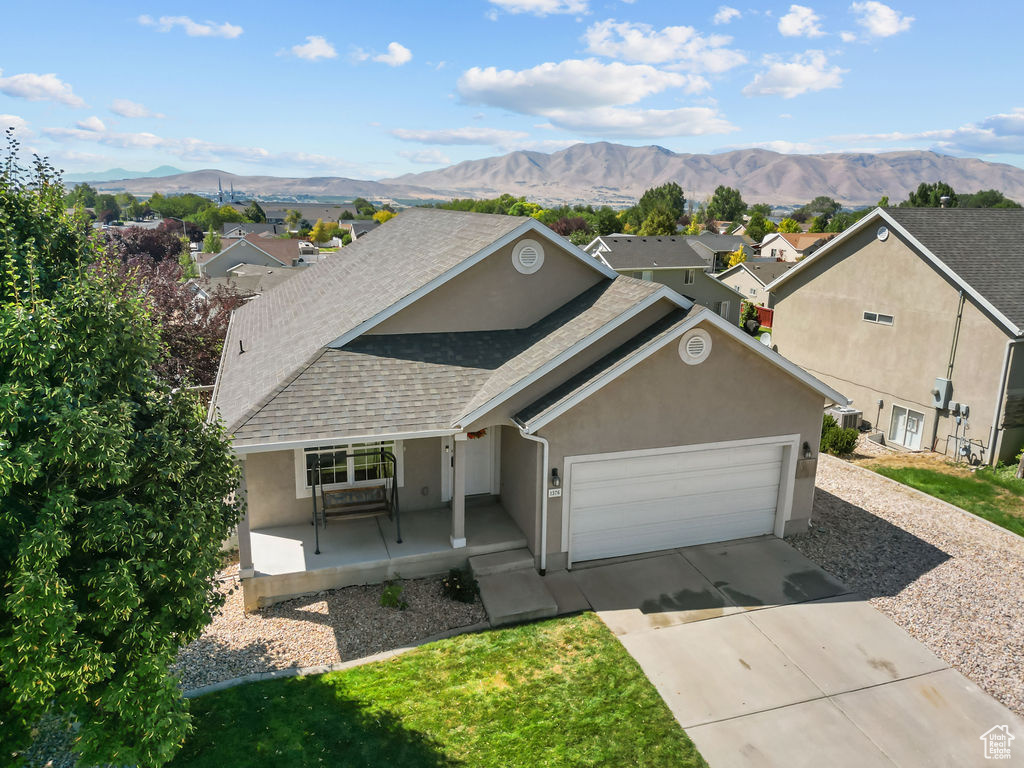 View of front of house with covered porch, a mountain view, and a garage