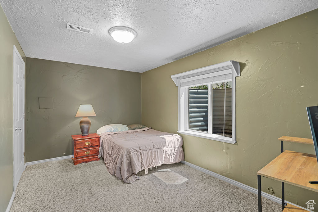 Bedroom featuring a textured ceiling and carpet flooring