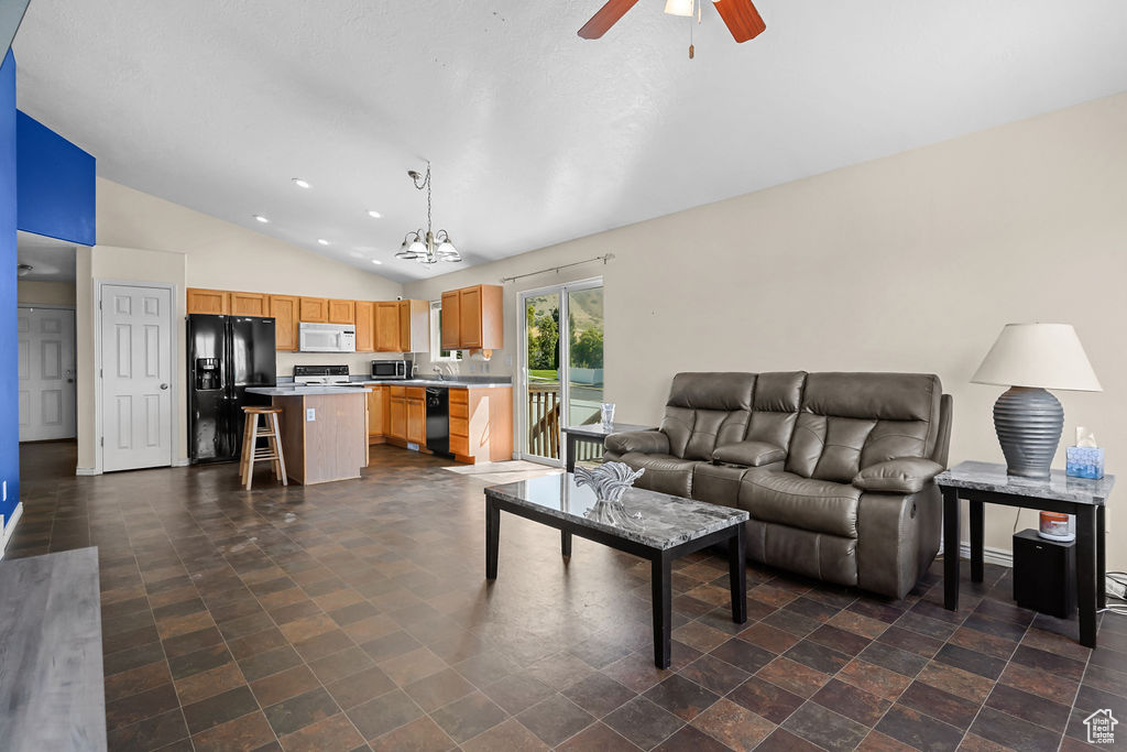 Living room featuring ceiling fan with notable chandelier and lofted ceiling