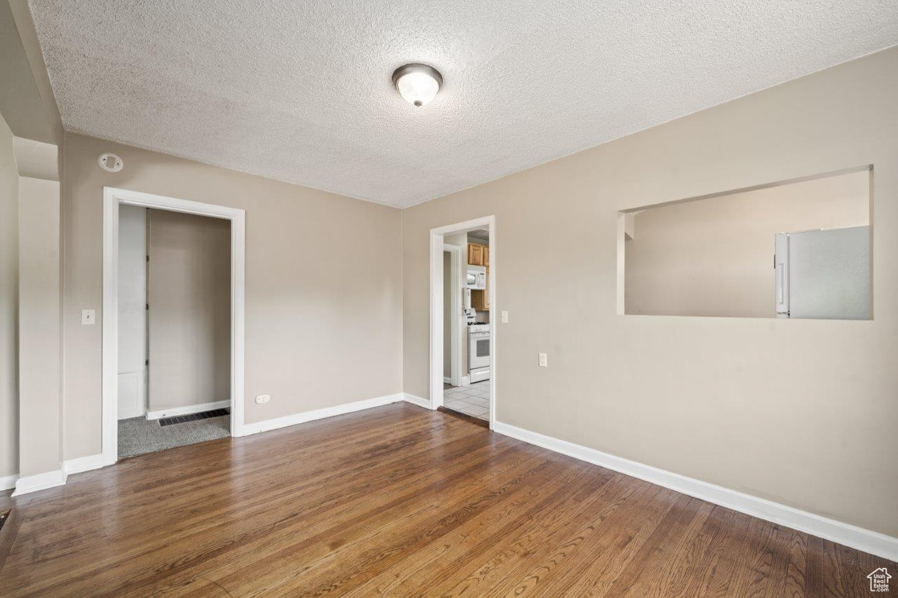 Spare room featuring wood-type flooring and a textured ceiling