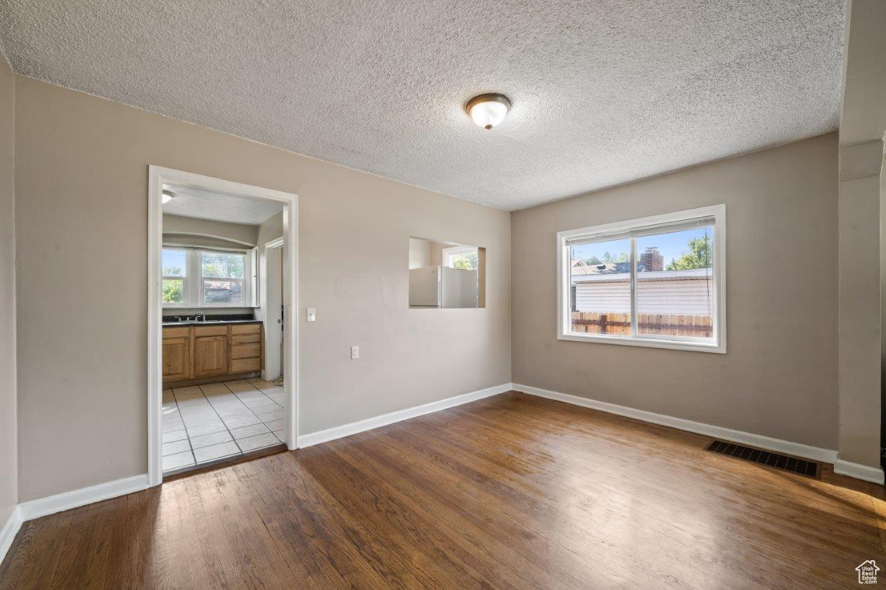 Spare room featuring a textured ceiling, light hardwood / wood-style flooring, and sink