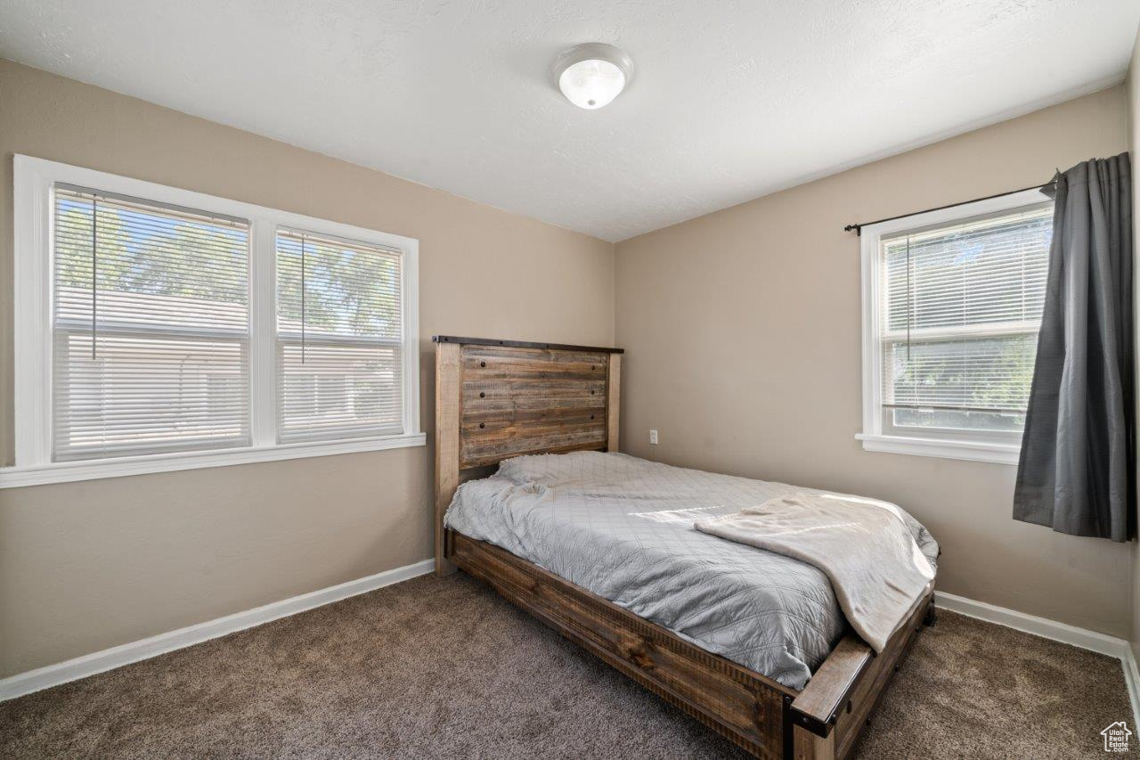 Bedroom featuring dark colored carpet