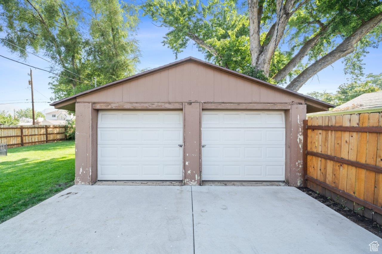 Garage featuring a lawn and wooden walls