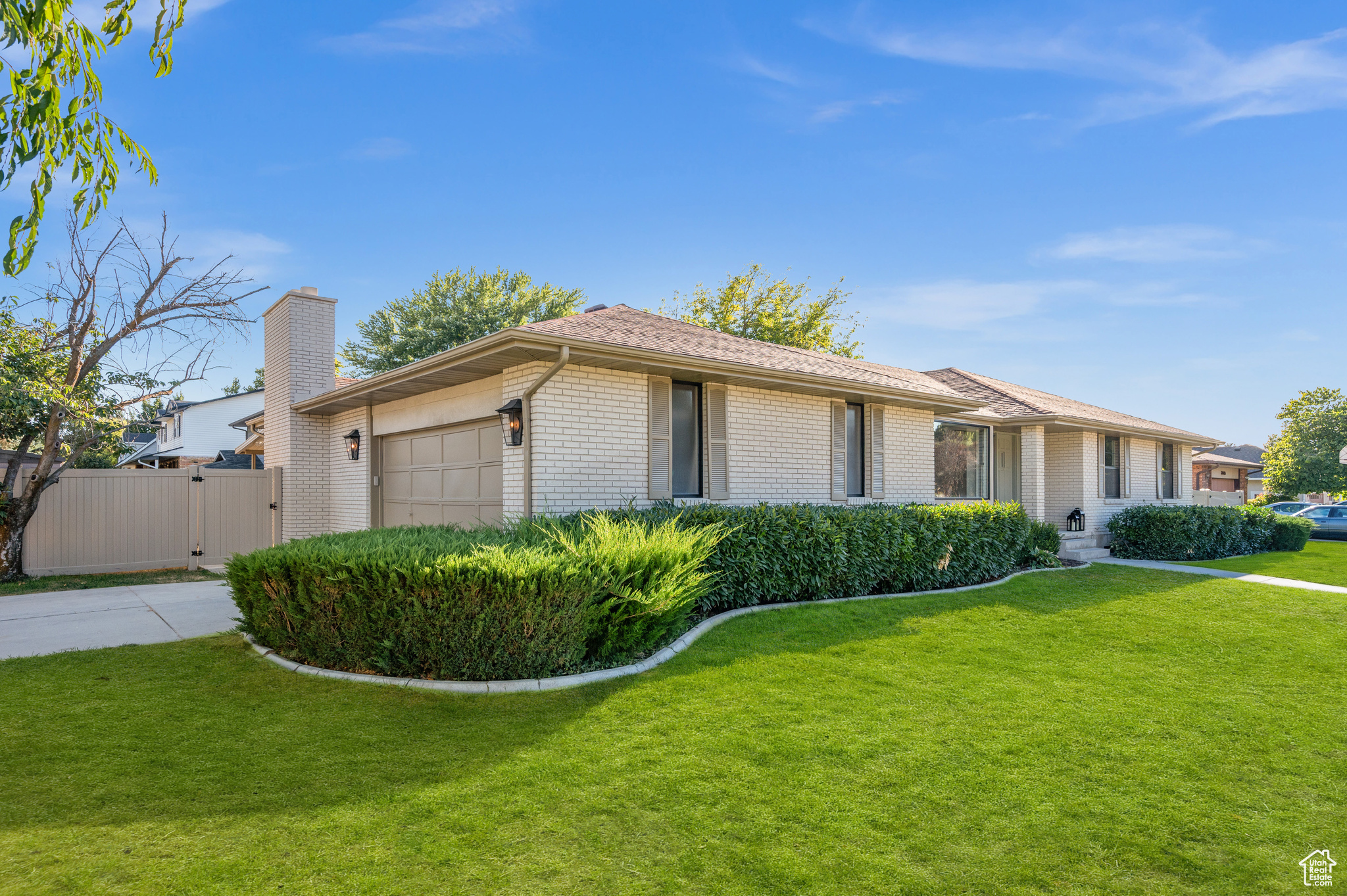 Ranch-style house featuring a garage and a front lawn