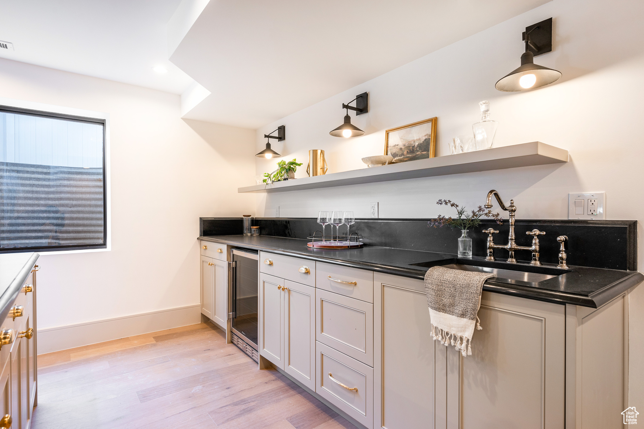 Kitchen featuring wine cooler, light hardwood / wood-style floors, and sink