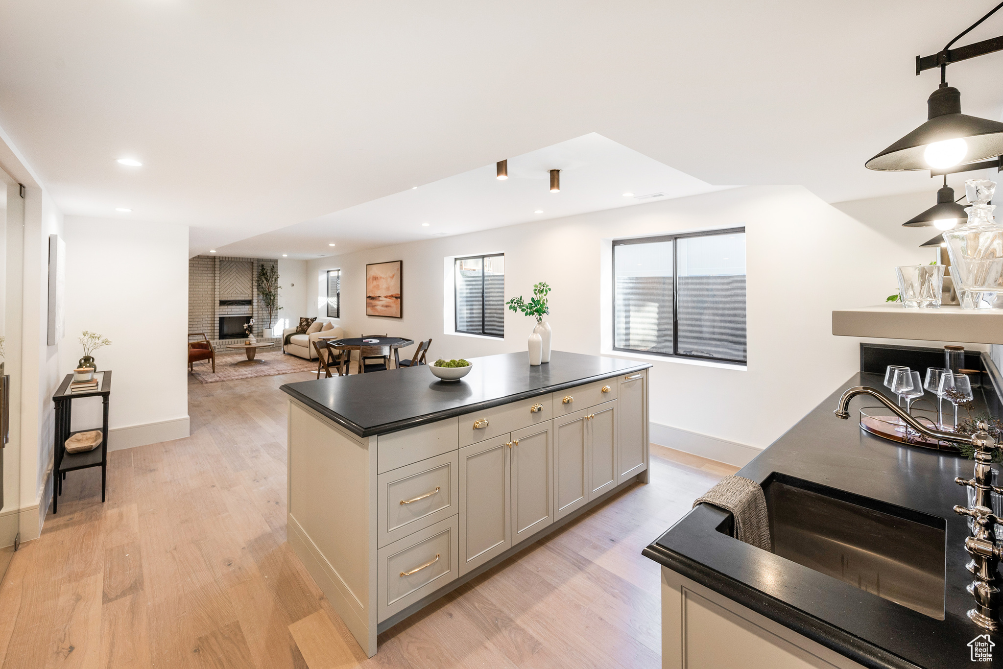 Kitchen featuring light wood-type flooring, a center island, and a fireplace