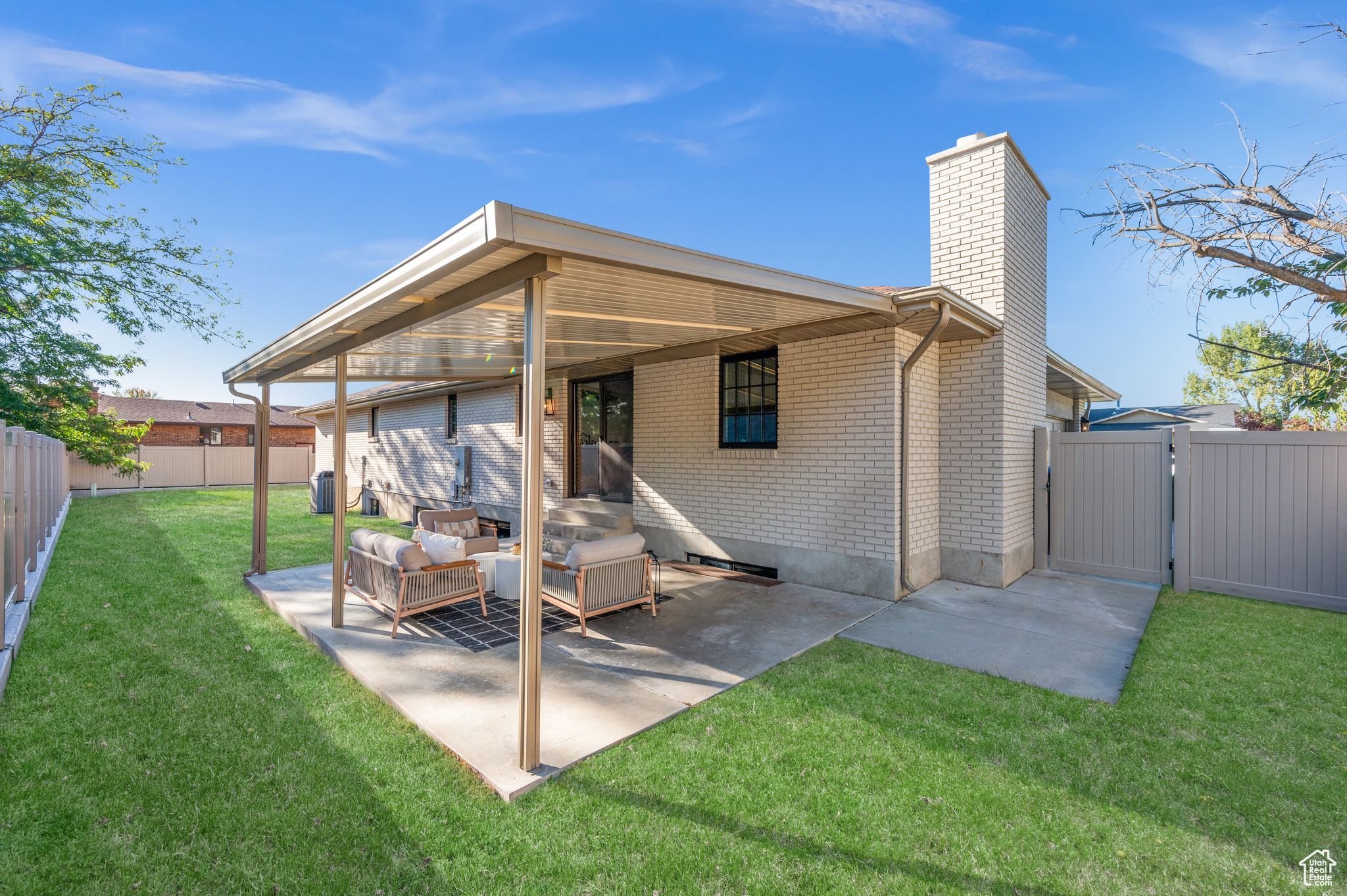 Back of property with a lawn, an outdoor living space, and a patio area