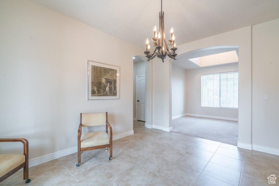 Dining area featuring an inviting chandelier and light carpet