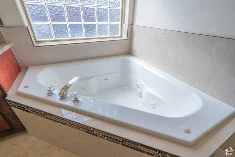 Bathroom featuring tile patterned flooring and tiled tub