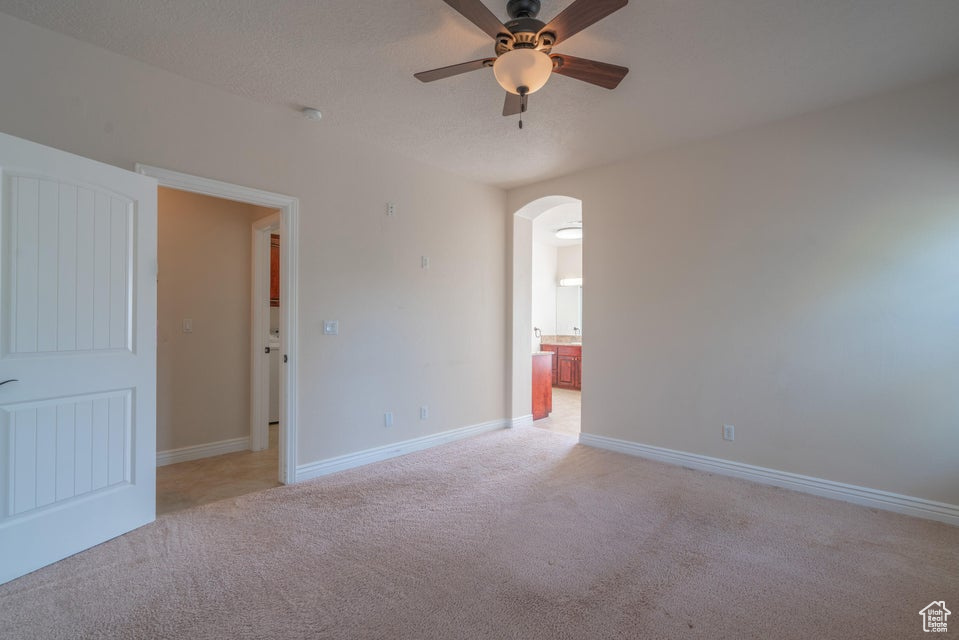 Carpeted empty room with ceiling fan