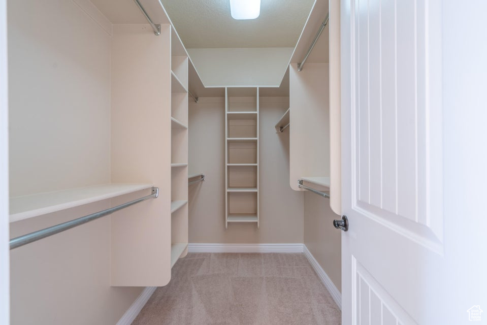 Walk in closet featuring light carpet