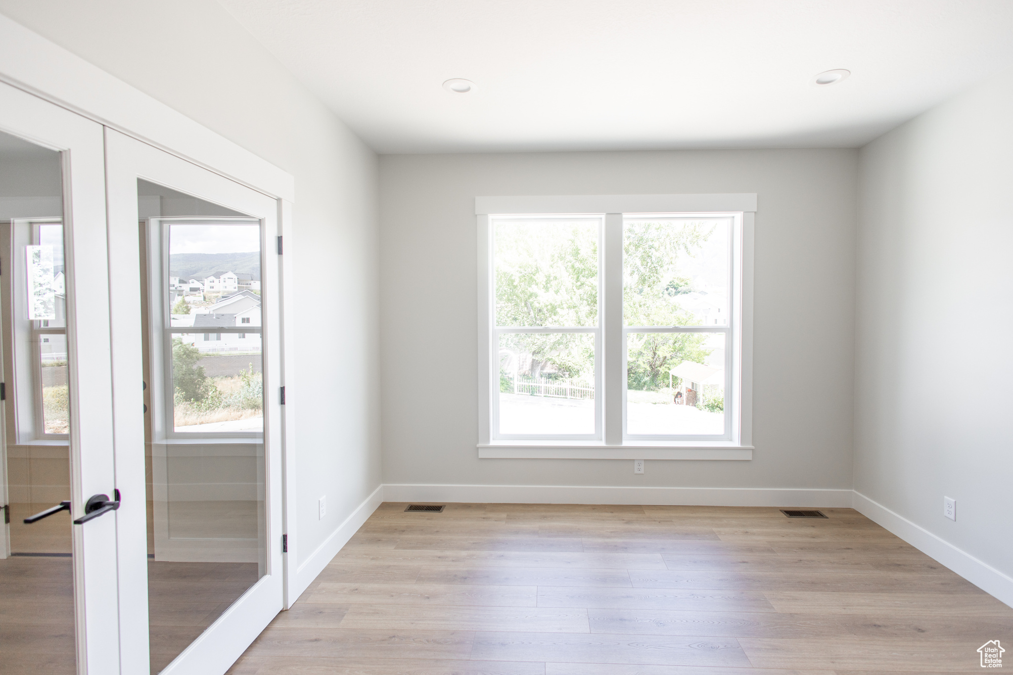 Den Featuring Glass French Doors and oversized windows.