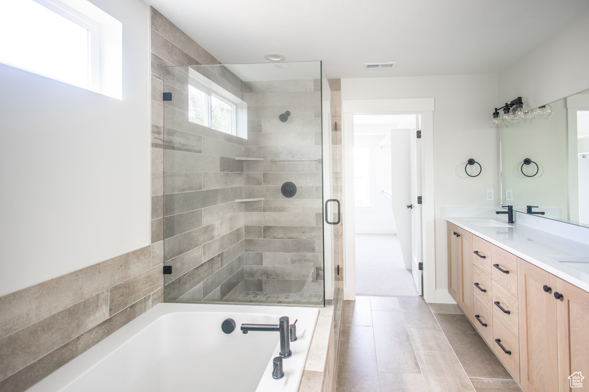 Huge Bathroom with walk-in glass shower, 6 foot tub, tile surrounds and double vanity