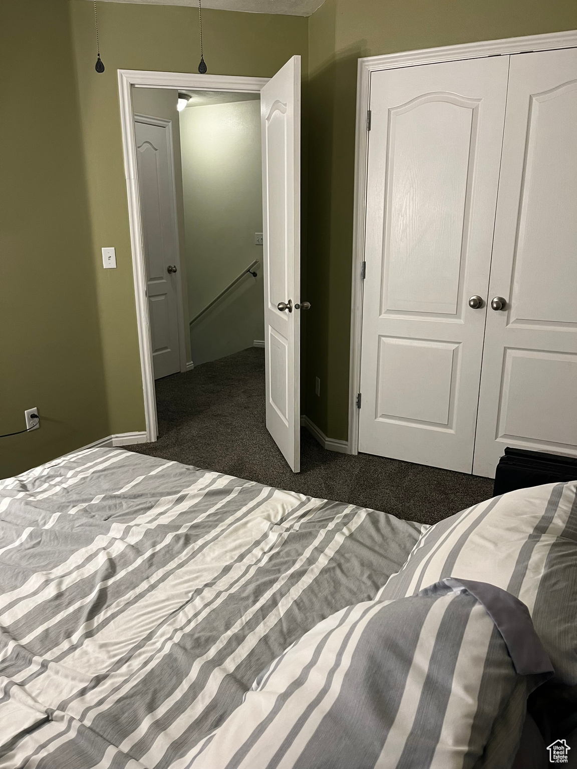 Bedroom with dark colored carpet and a closet