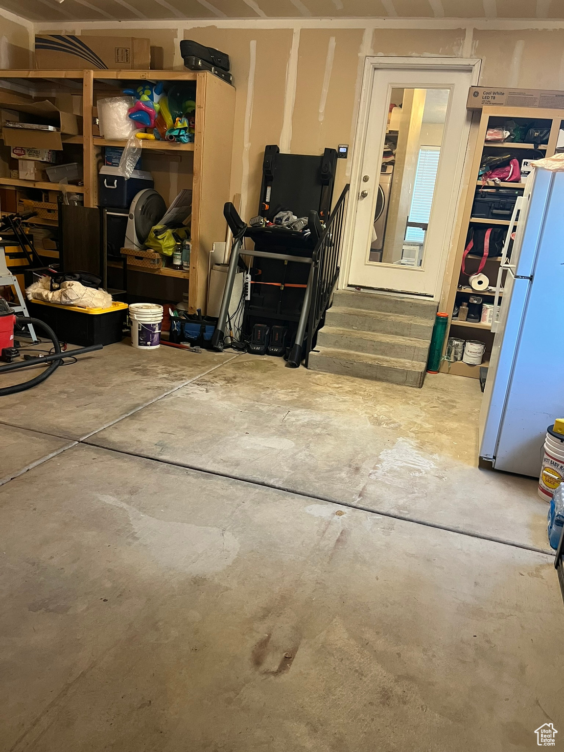 Interior space featuring washer / clothes dryer and white refrigerator