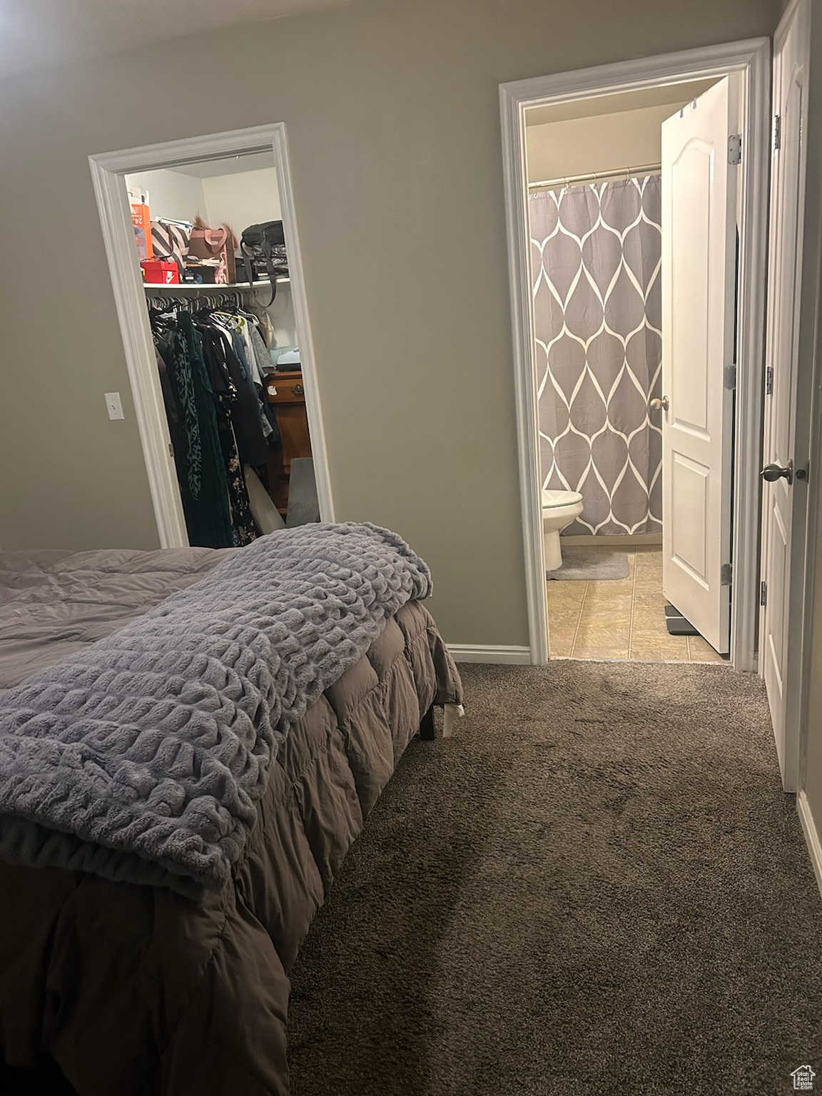 Bedroom featuring ensuite bath, a closet, a spacious closet, and light carpet