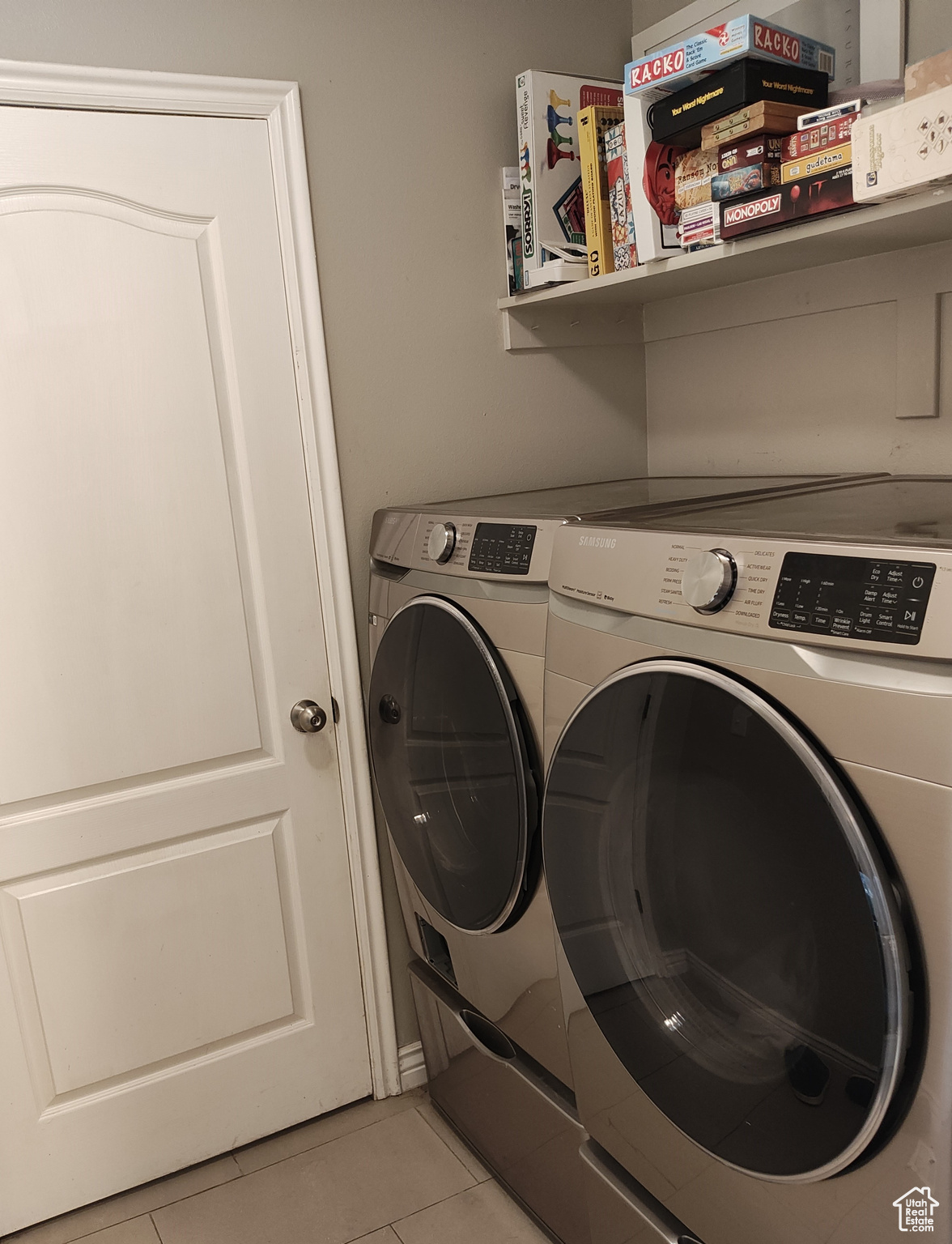 Laundry room with separate washer and dryer and light tile patterned floors