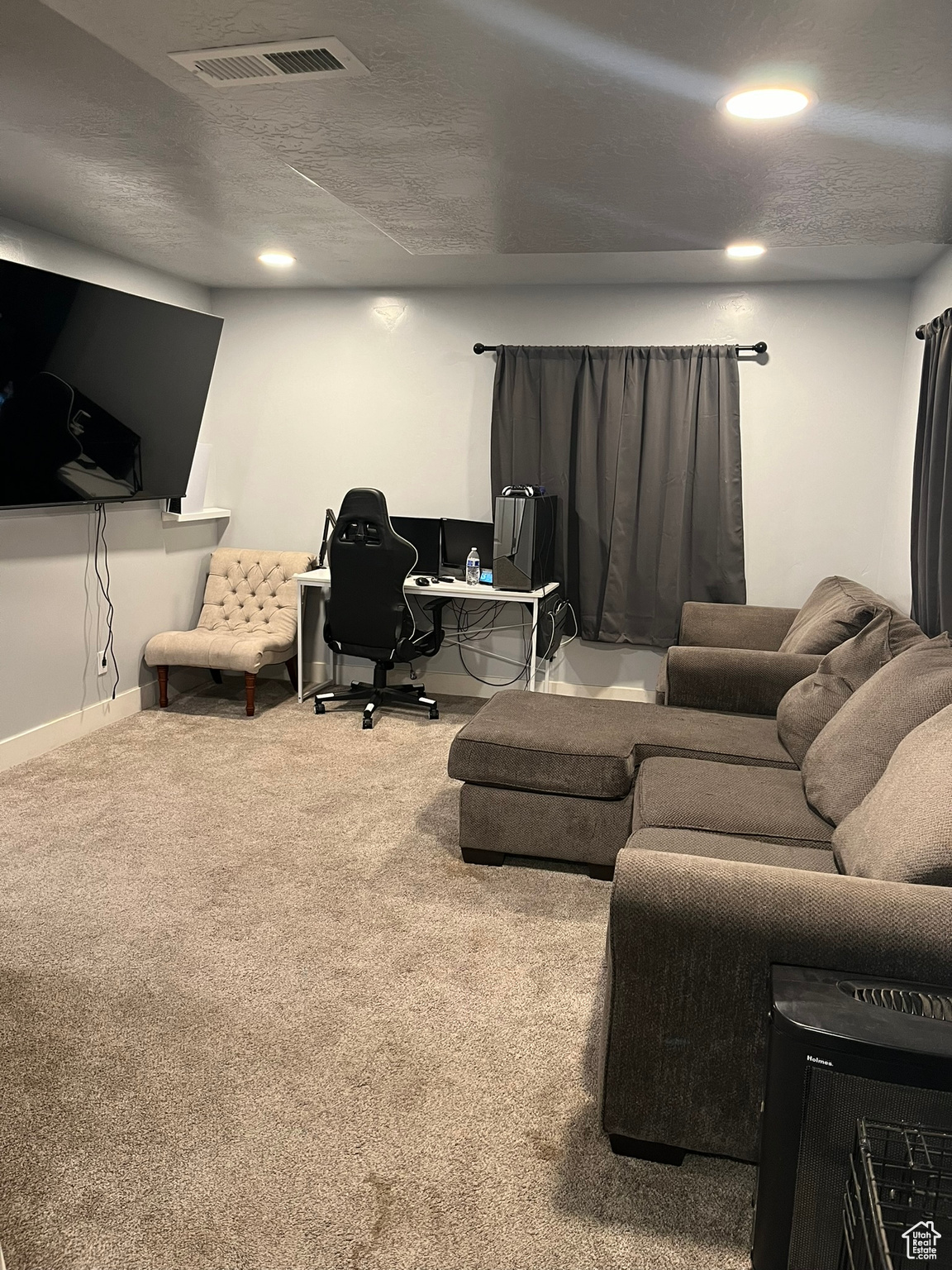 Carpeted living room with a textured ceiling