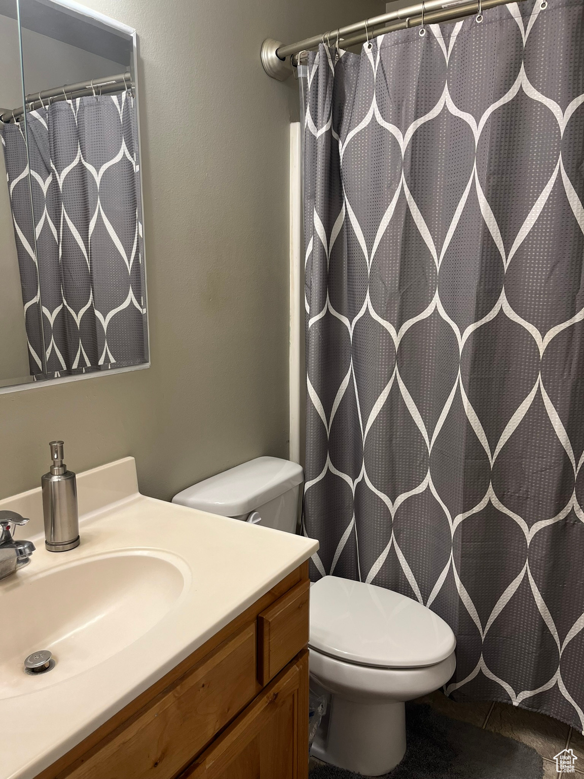 Bathroom with vanity, toilet, and a shower with curtain