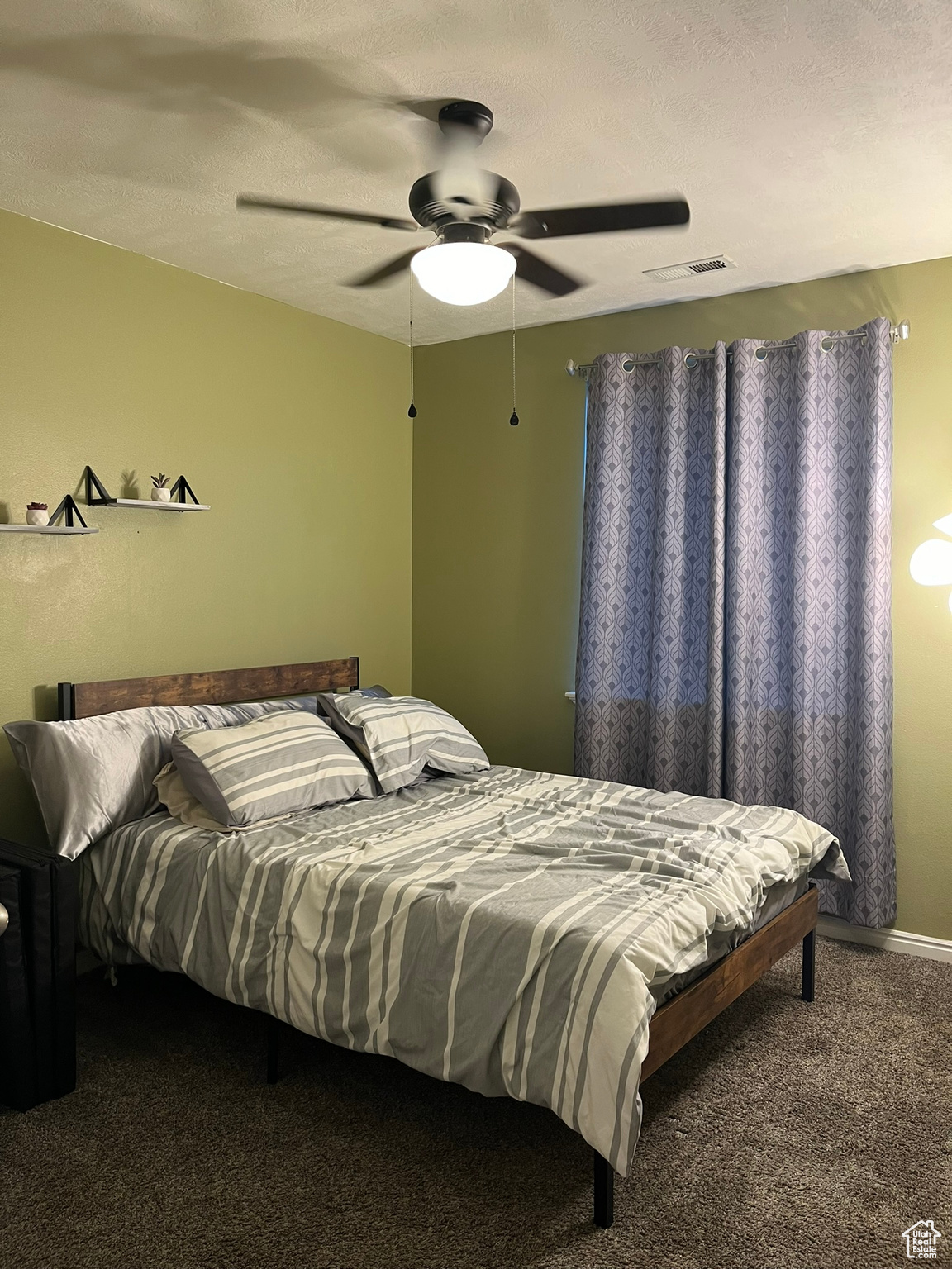 Bedroom featuring ceiling fan, a textured ceiling, and carpet floors