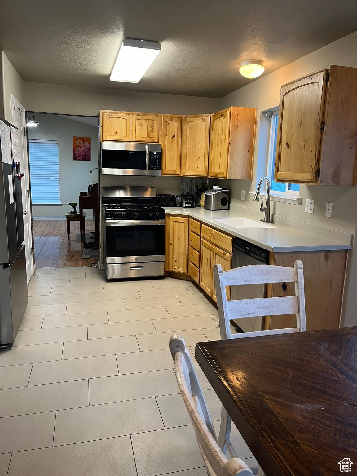 Kitchen featuring light hardwood / wood-style flooring, stainless steel appliances, a textured ceiling, and sink