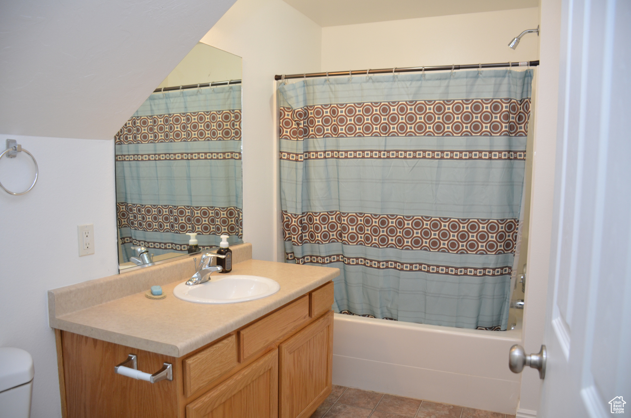 Full bathroom featuring vanity, toilet, tile patterned floors, and shower / bath combination with curtain