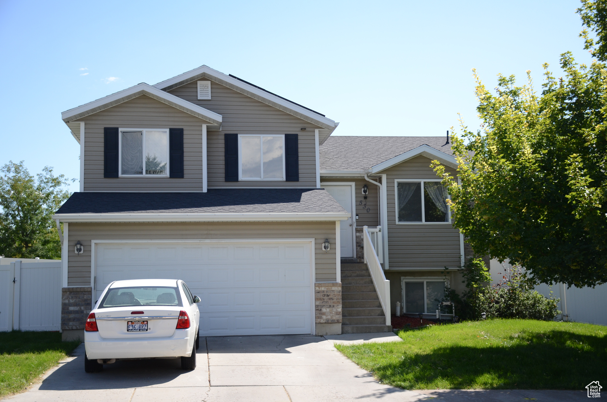 Split level home with a garage and a front yard