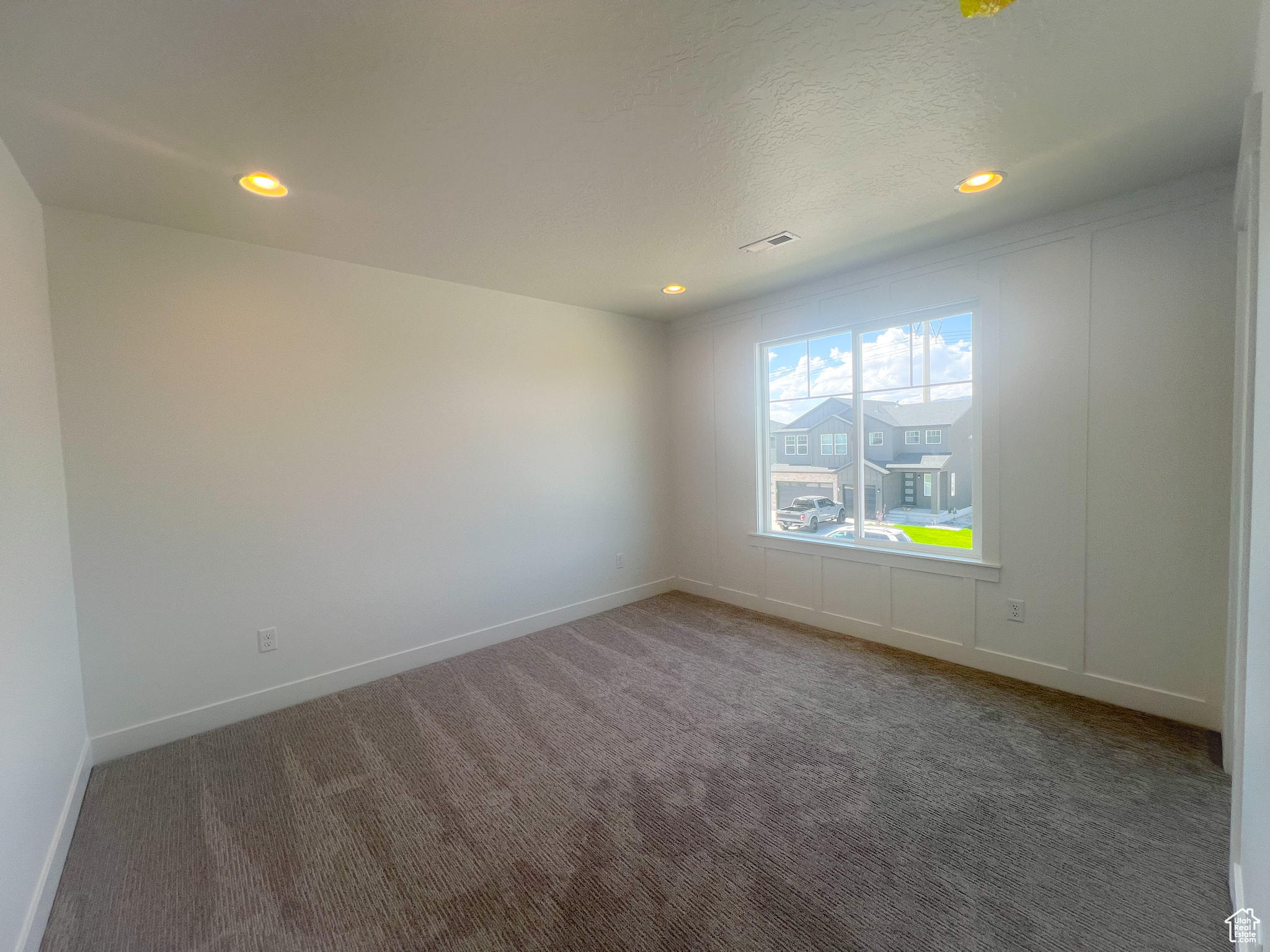 Carpeted spare room with a textured ceiling