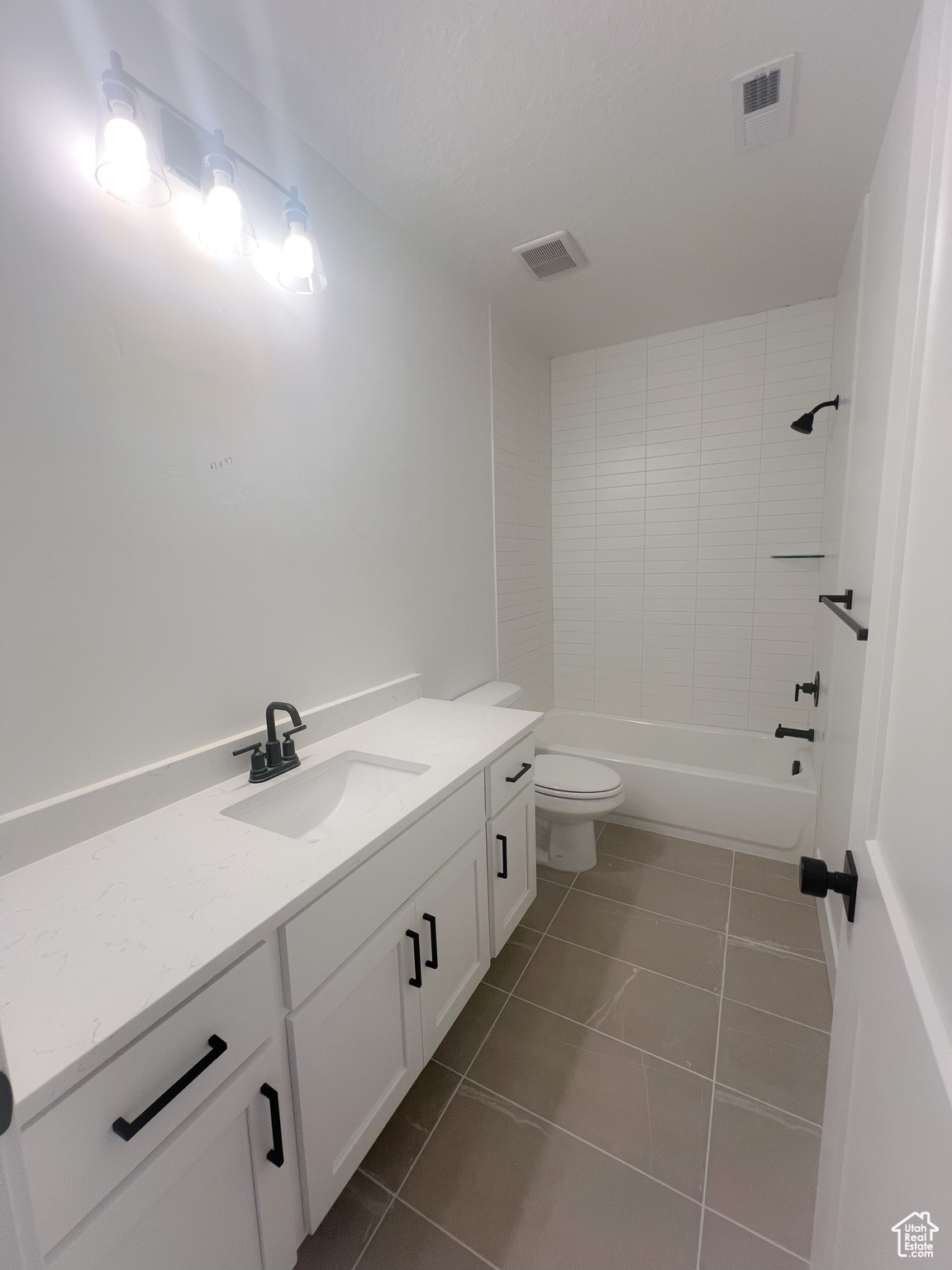 Full bathroom with vanity, toilet, washtub / shower combination, and tile patterned flooring