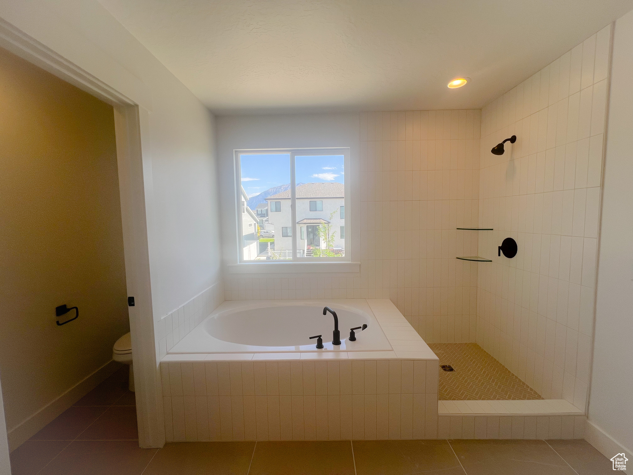 Bathroom featuring toilet, independent shower and bath, and tile patterned floors