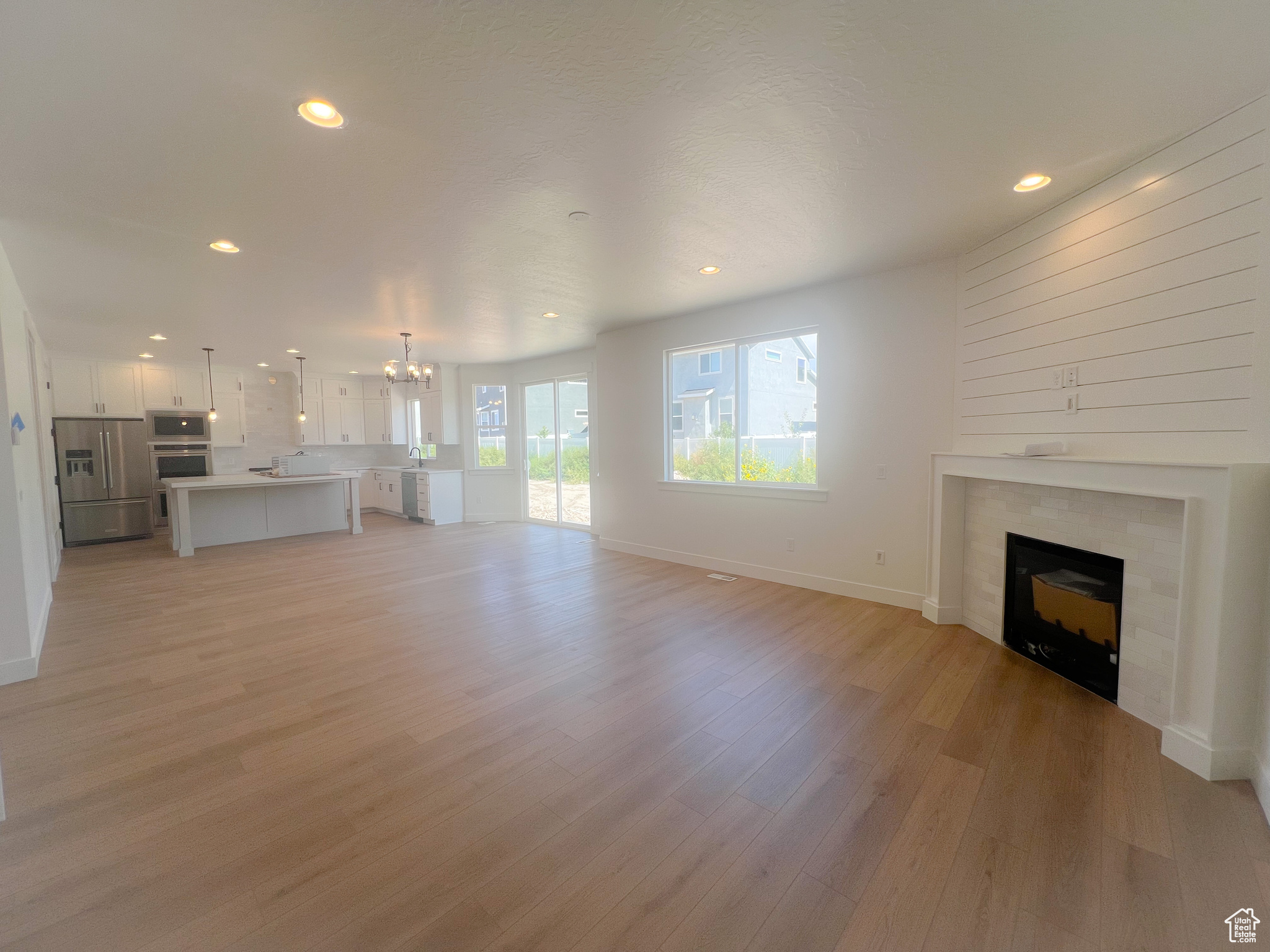 Unfurnished living room with an inviting chandelier and light hardwood / wood-style floors