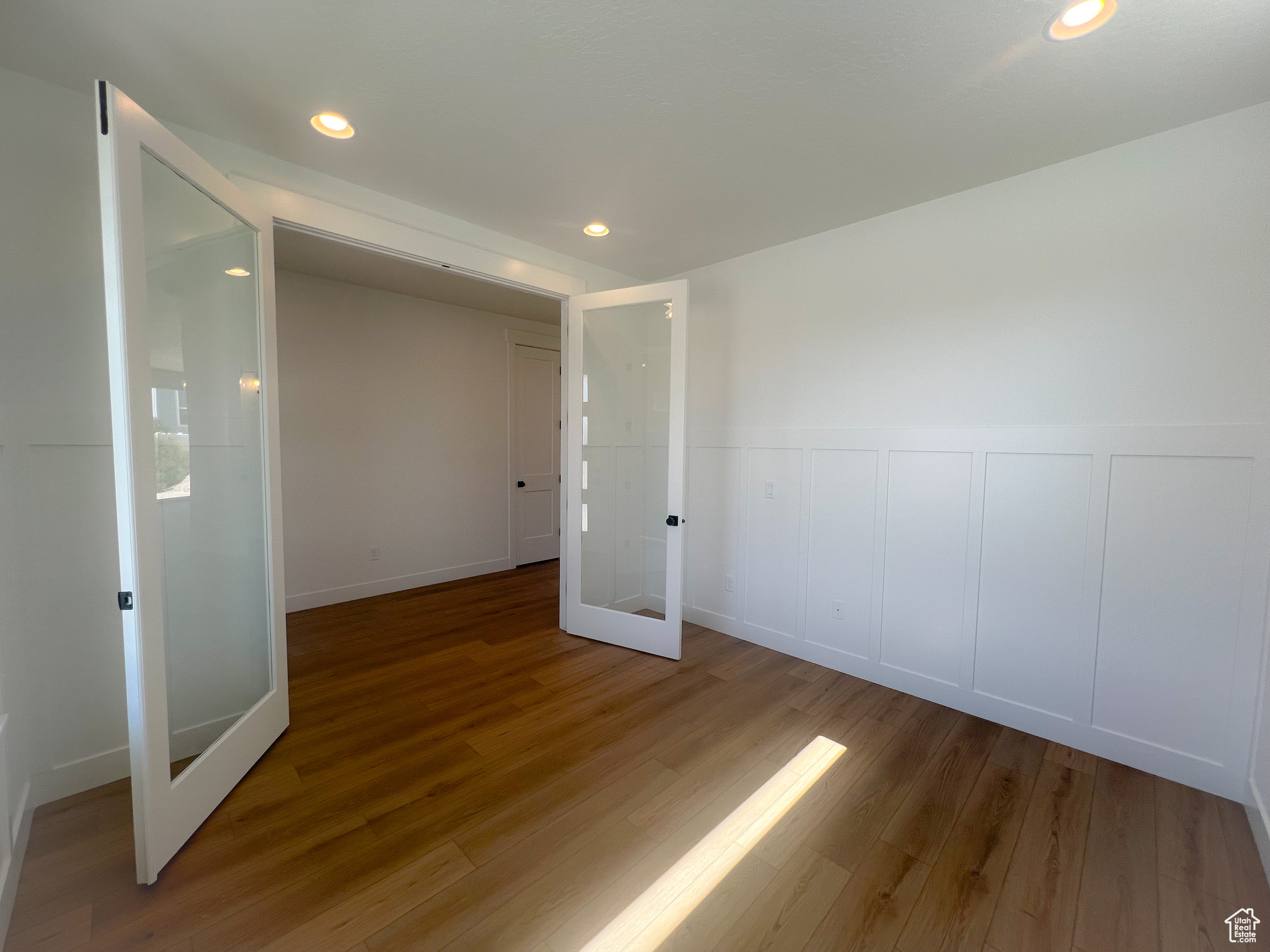 Empty room with french doors and hardwood / wood-style flooring