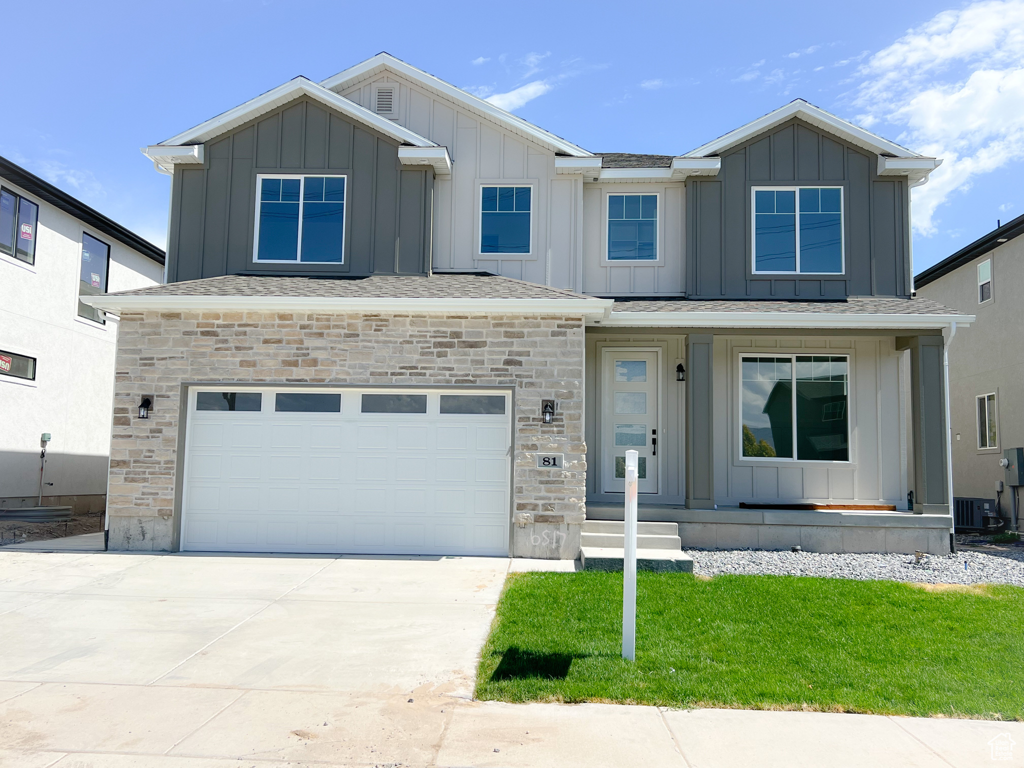 View of front of property featuring cooling unit, a garage, and a front yard