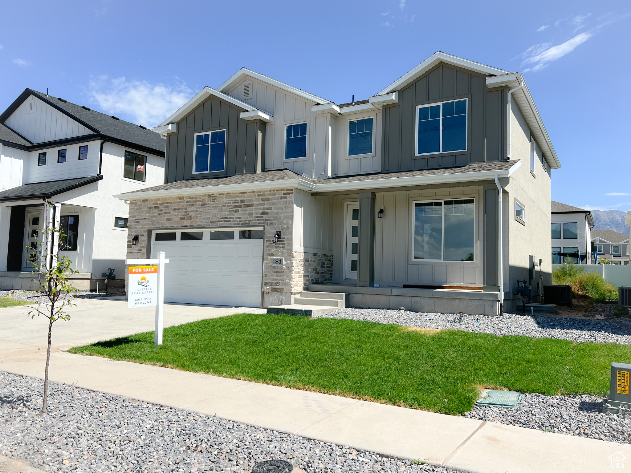 View of front of home with a garage, a porch, and a front lawn